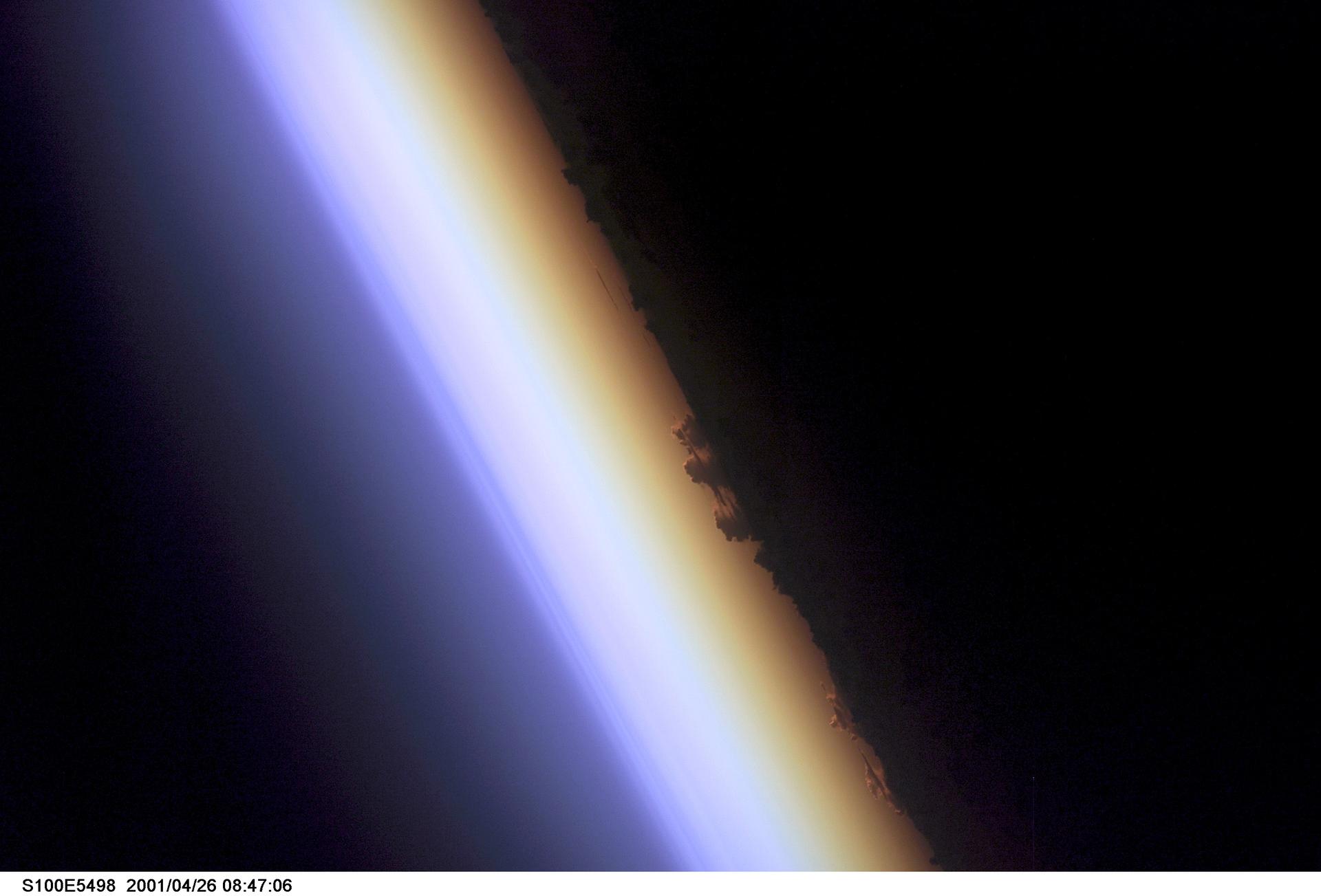 Limbe de la Terre au crépuscule vu depuis l'espace, avec la fine couche lumineuse de l'atmosphère