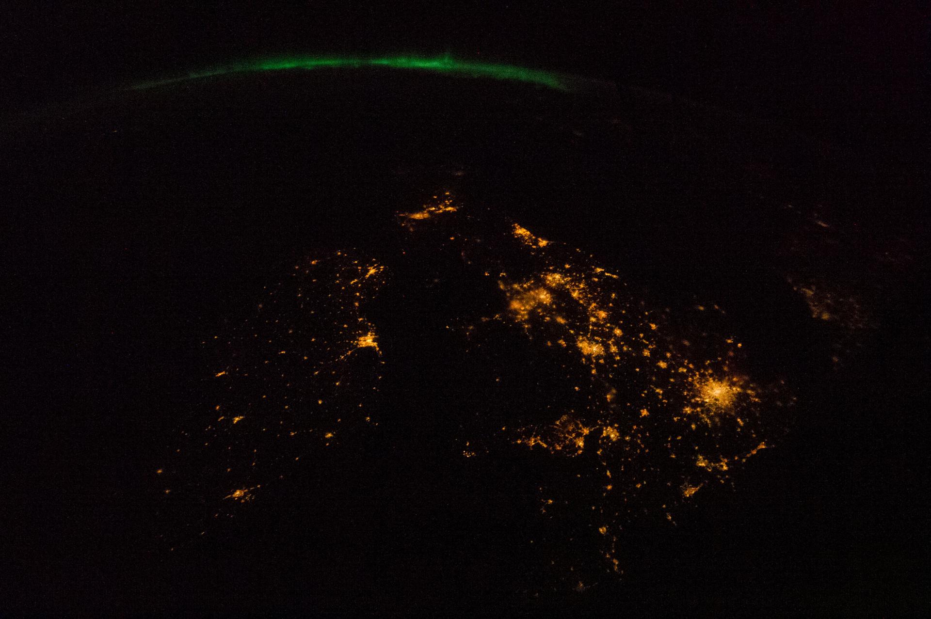Les îles Britanniques photographiées de nuit depuis la Station spatiale internationale, avec une aurore boréale à l'horizon